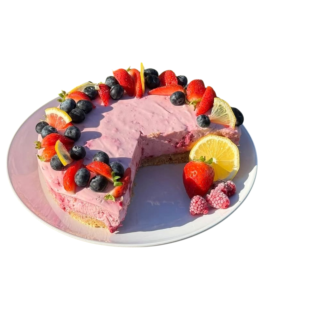Pink berry cheesecake topped with strawberries and blueberries